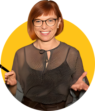 Das Bild zeigt Astrid Leutner, eine Trainerin aus dem ZamStarten Gründerzentrum. Sie hat rot gefärbte halslange Haare, eine schwarze Brille und lächelt. Sie streckt ihre Hände öffnend dem Betrachtenden entgegen.